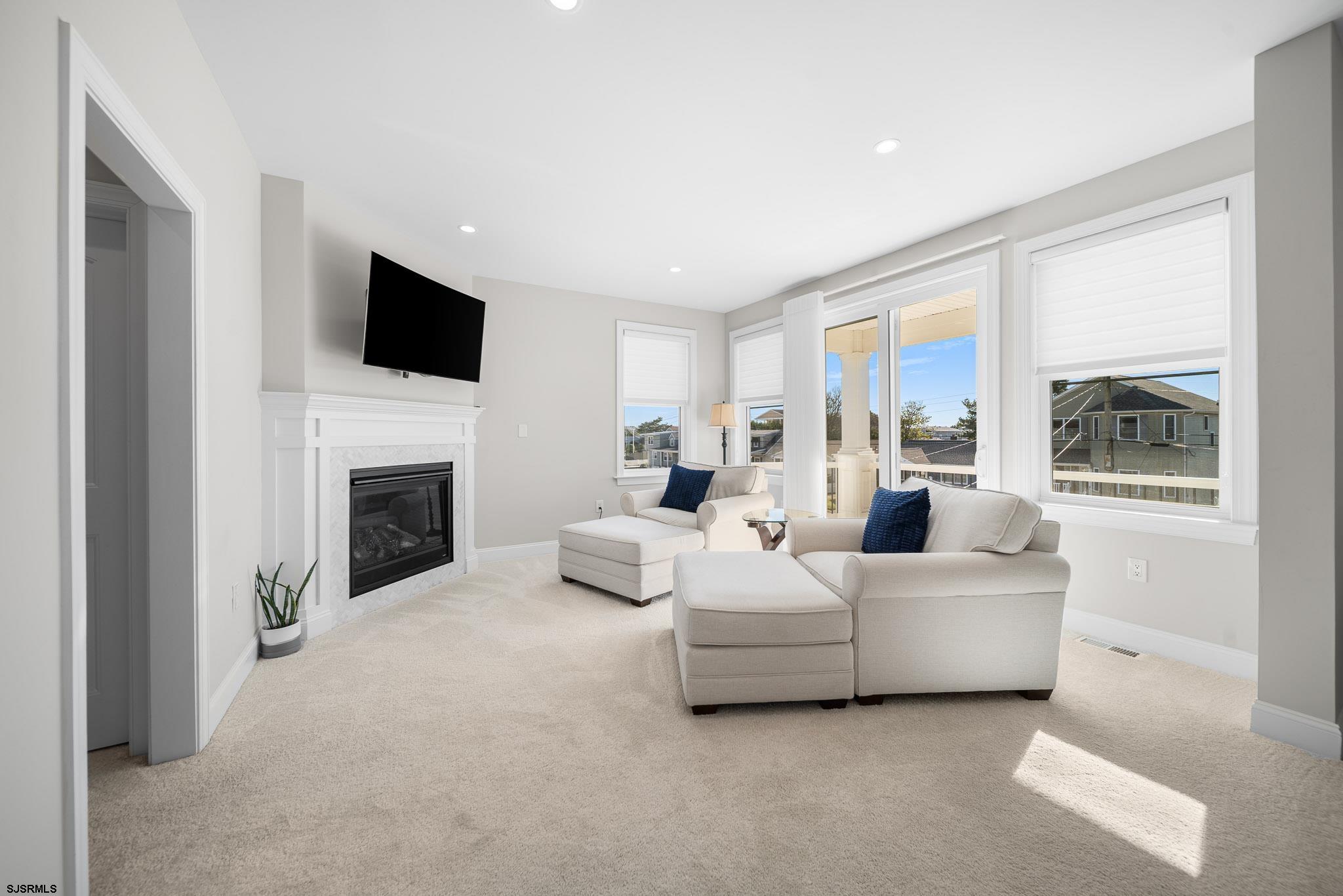 223 8th Street South Brigantine, NJ 08203 - Photo 15 of 46 a living room with furniture a fireplace and a flat screen tv