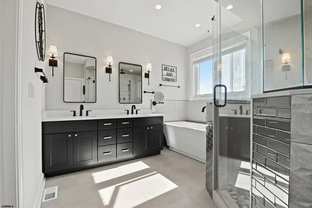 a spacious bathroom with a double vanity sink a large mirror and a bathtub
