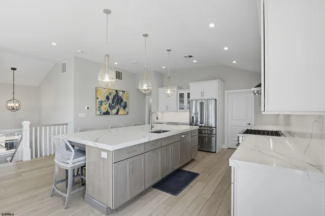a large kitchen with cabinets wooden floor and stainless steel appliances