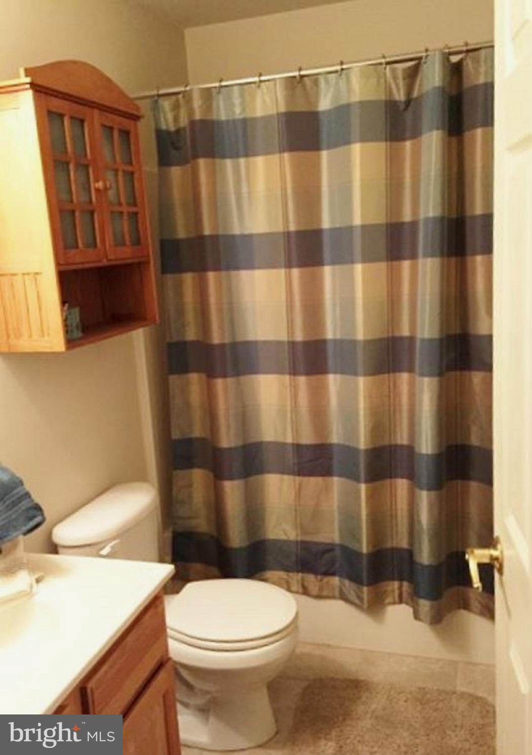 2416 Lodge Farm Road Baltimore, MD 21219 - Photo 12 of 12 a white toilet sitting next to a shower curtain