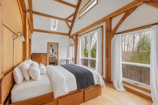 a bedroom with a bed and a large window
