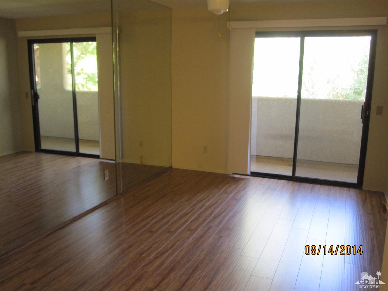 69593 Karen Way Rancho Mirage, CA 92270 - Photo 4 of 8 an empty room with wooden floor and windows