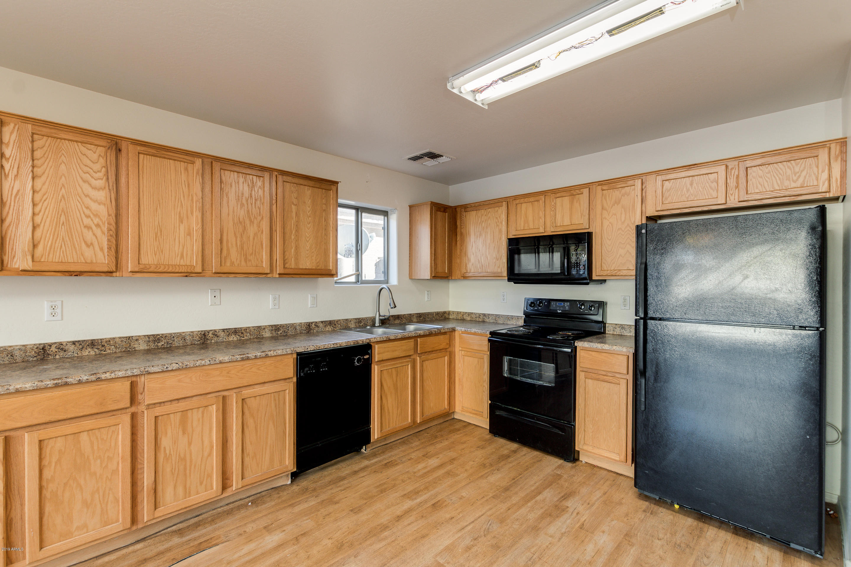 3732 West Fremont Rd. Phoenix, AZ 85041 - Photo 3 of 34 a kitchen with granite countertop stainless steel appliances and wooden cabinets