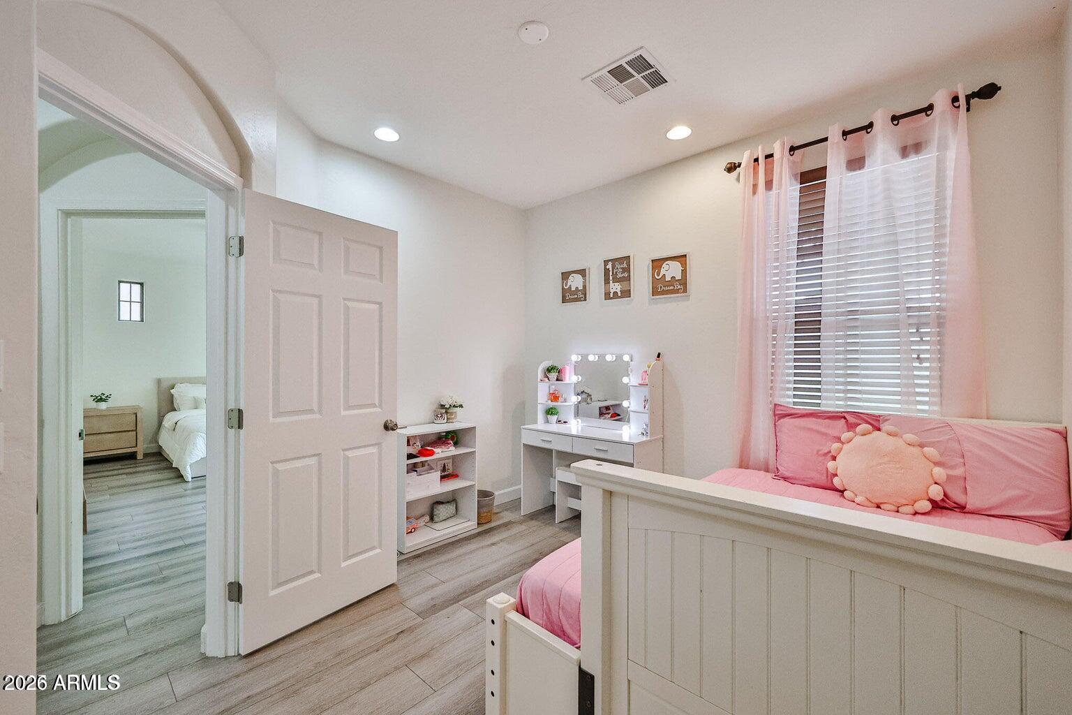 3950 North Edith Way Buckeye, AZ 85396 - Photo 19 of 32 a bedroom with a bed and wooden floor