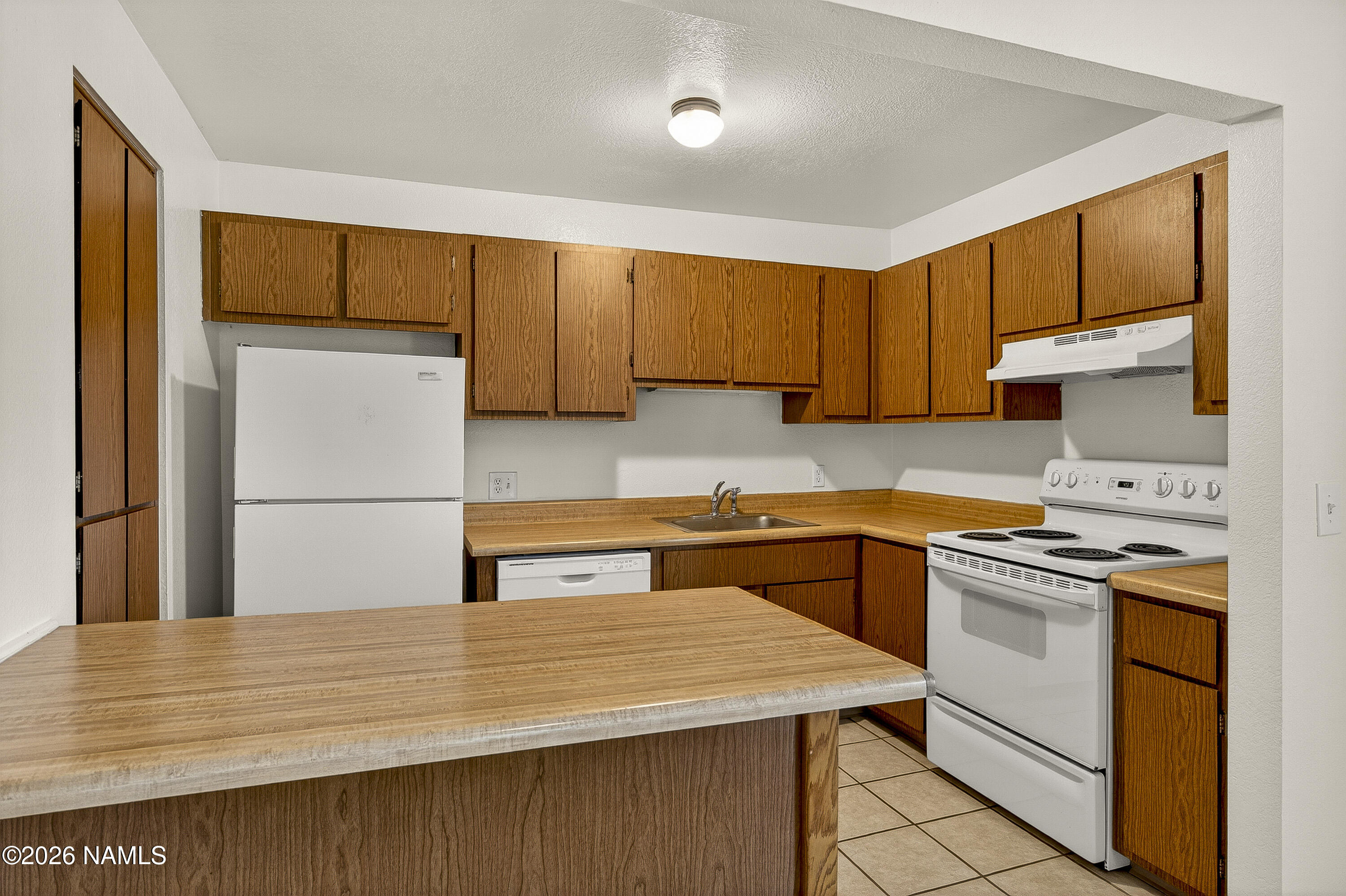 1200 South Riordan Ranch Street, Unit 112 Flagstaff, AZ 86001 - Photo 7 of 22 a kitchen with stainless steel appliances granite countertop a stove a sink and a refrigerator