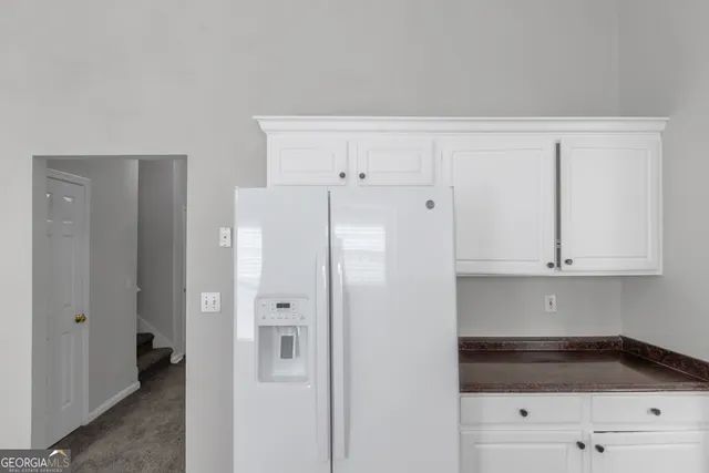 a kitchen with stainless steel appliances white cabinets and a refrigerator