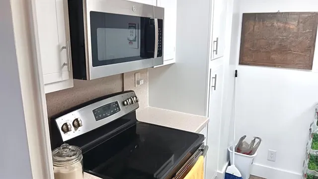 a close view of a sink and a stove with wooden floor