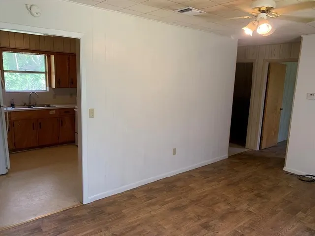 an empty room with kitchen and windows