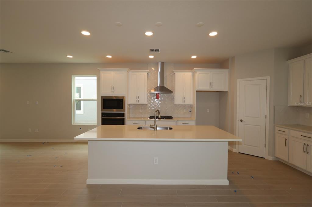 5276 Ctr Lk Rnch Boulevard St. Cloud, FL 34771 - Photo 2 of 23 a large kitchen with kitchen island a sink stainless steel appliances and cabinets