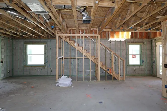 a room with lots of white furniture and a window