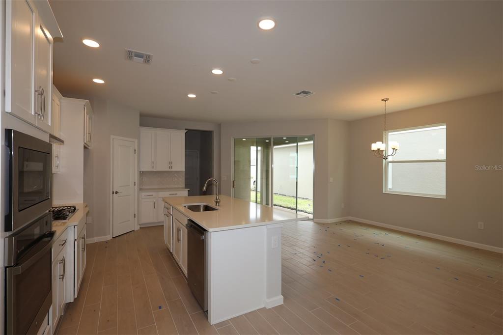 5276 Ctr Lk Rnch Boulevard St. Cloud, FL 34771 - Photo 4 of 23 a kitchen with stainless steel appliances a stove top oven a sink a refrigerator and a window