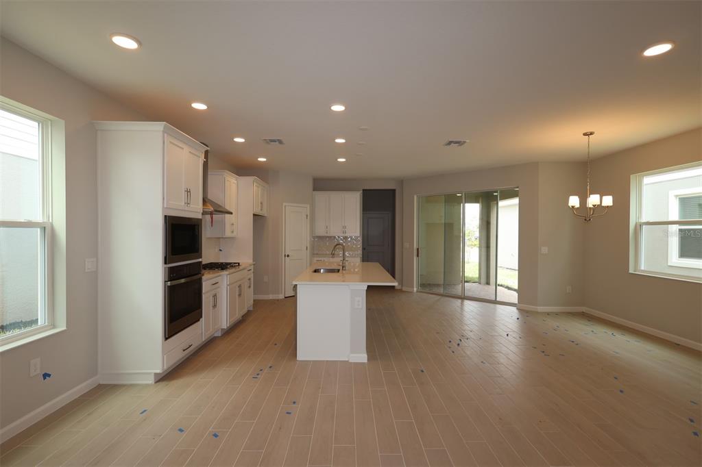 5276 Ctr Lk Rnch Boulevard St. Cloud, FL 34771 - Photo 5 of 23 a view of kitchen with stainless steel appliances kitchen island wooden floors and white walls