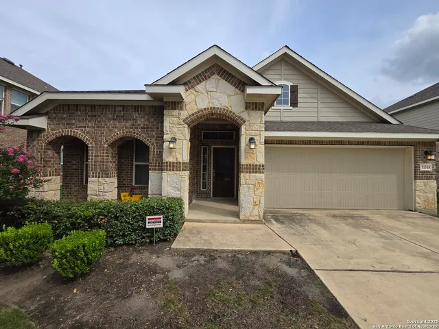 a front view of a house with a garden and garage
