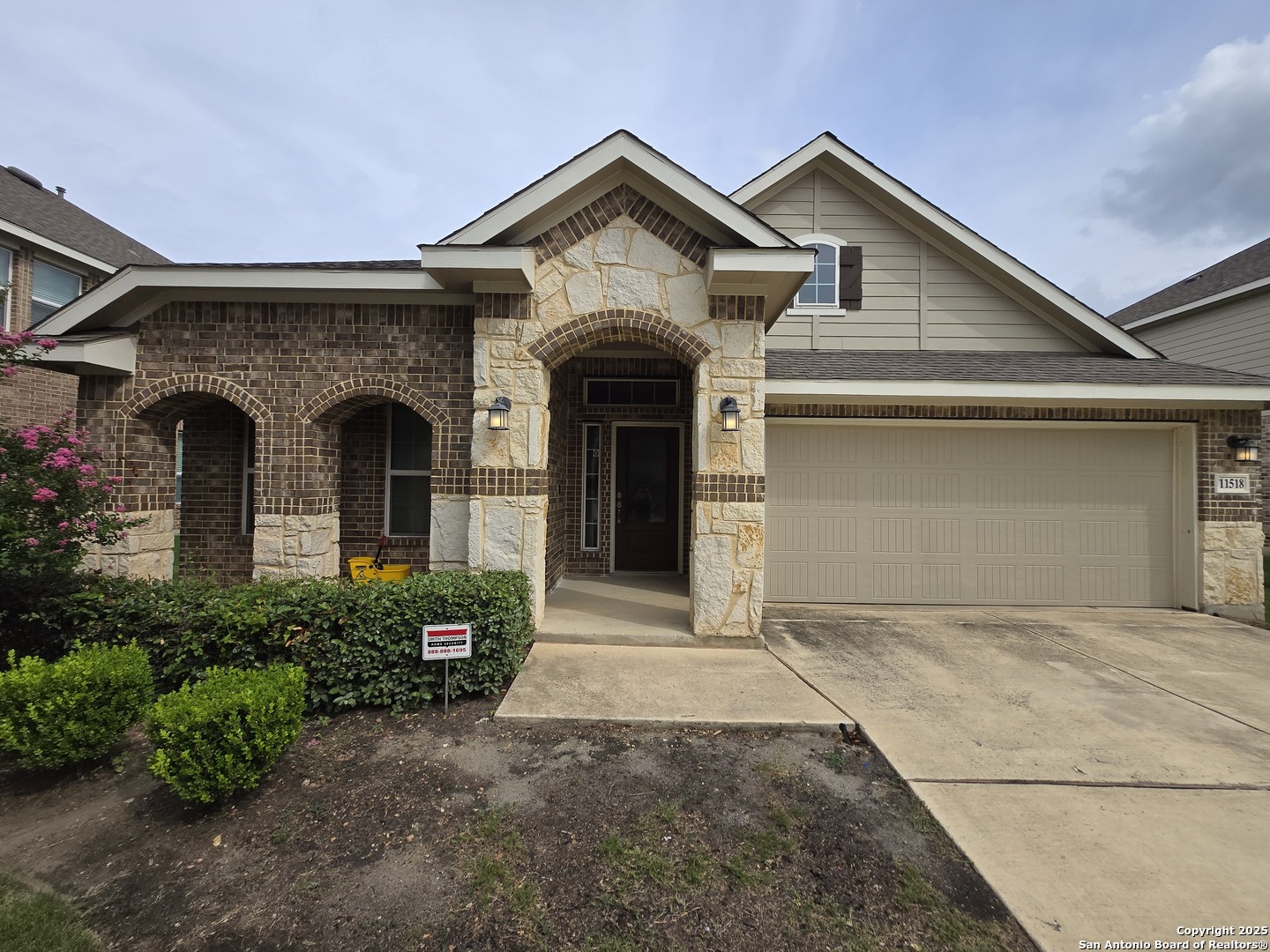 a front view of a house with a garden and garage