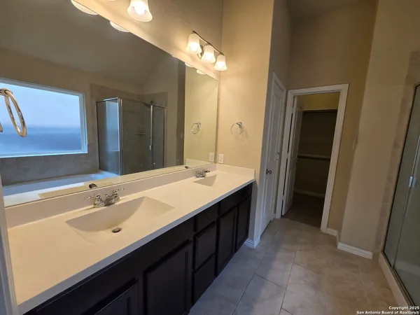 a bathroom with a double vanity sink and a mirror