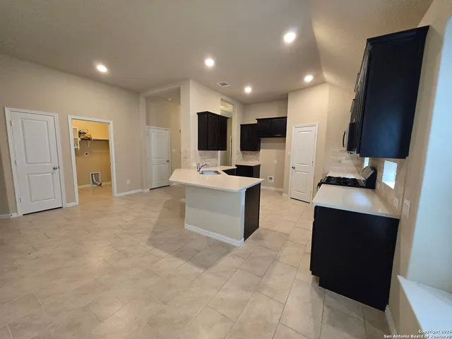 a large kitchen with stainless steel appliances a sink a stove and a refrigerator