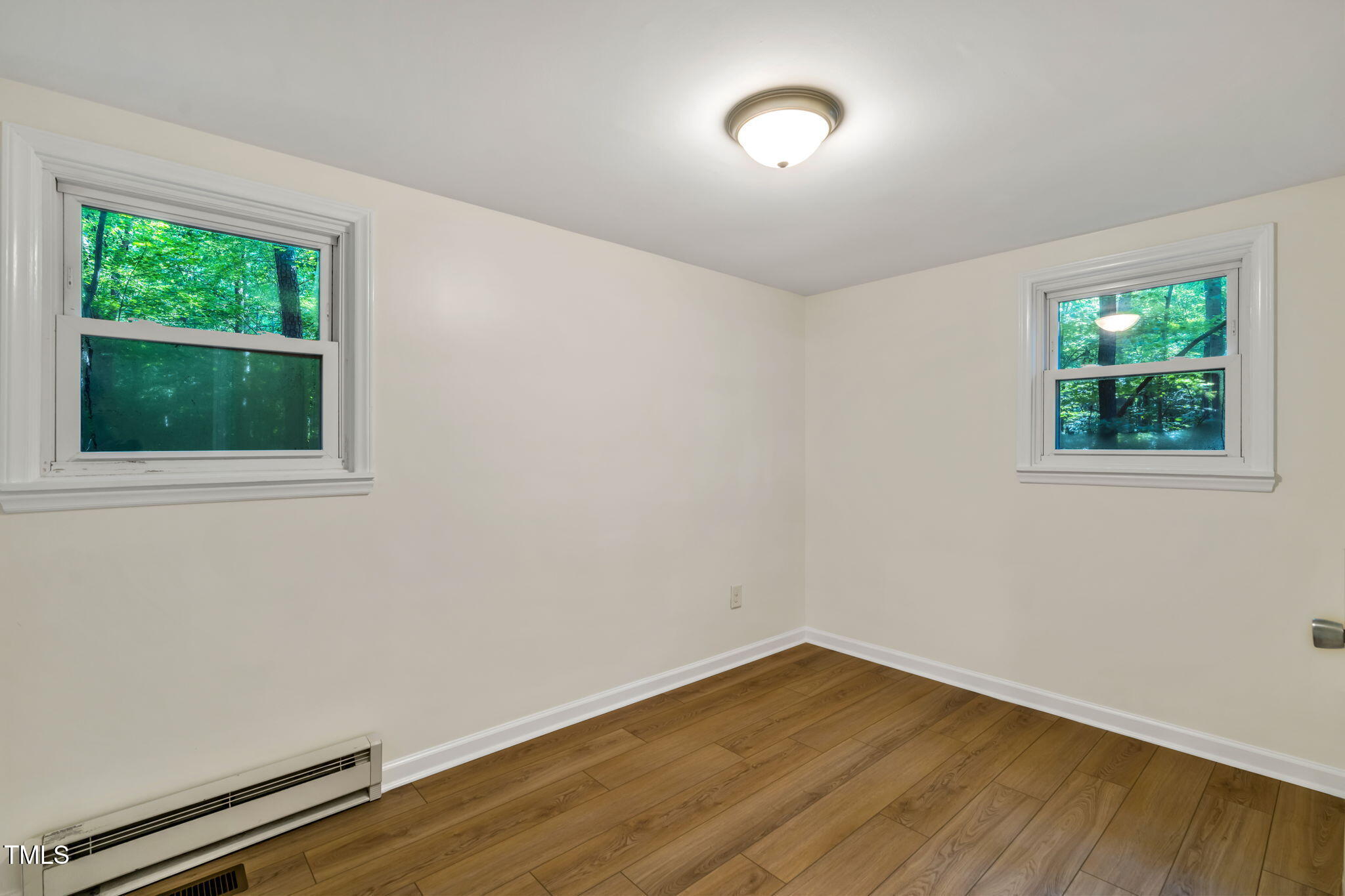 5500 Bobbitt Road Apex, NC 27539 - Photo 14 of 23 a view of an empty room with wooden floor and a window