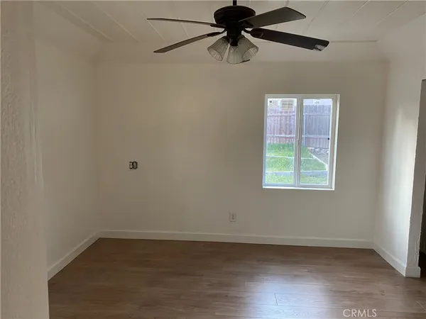 an empty room with a window and a fan