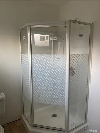 a bathroom with a glass shower door and mirror