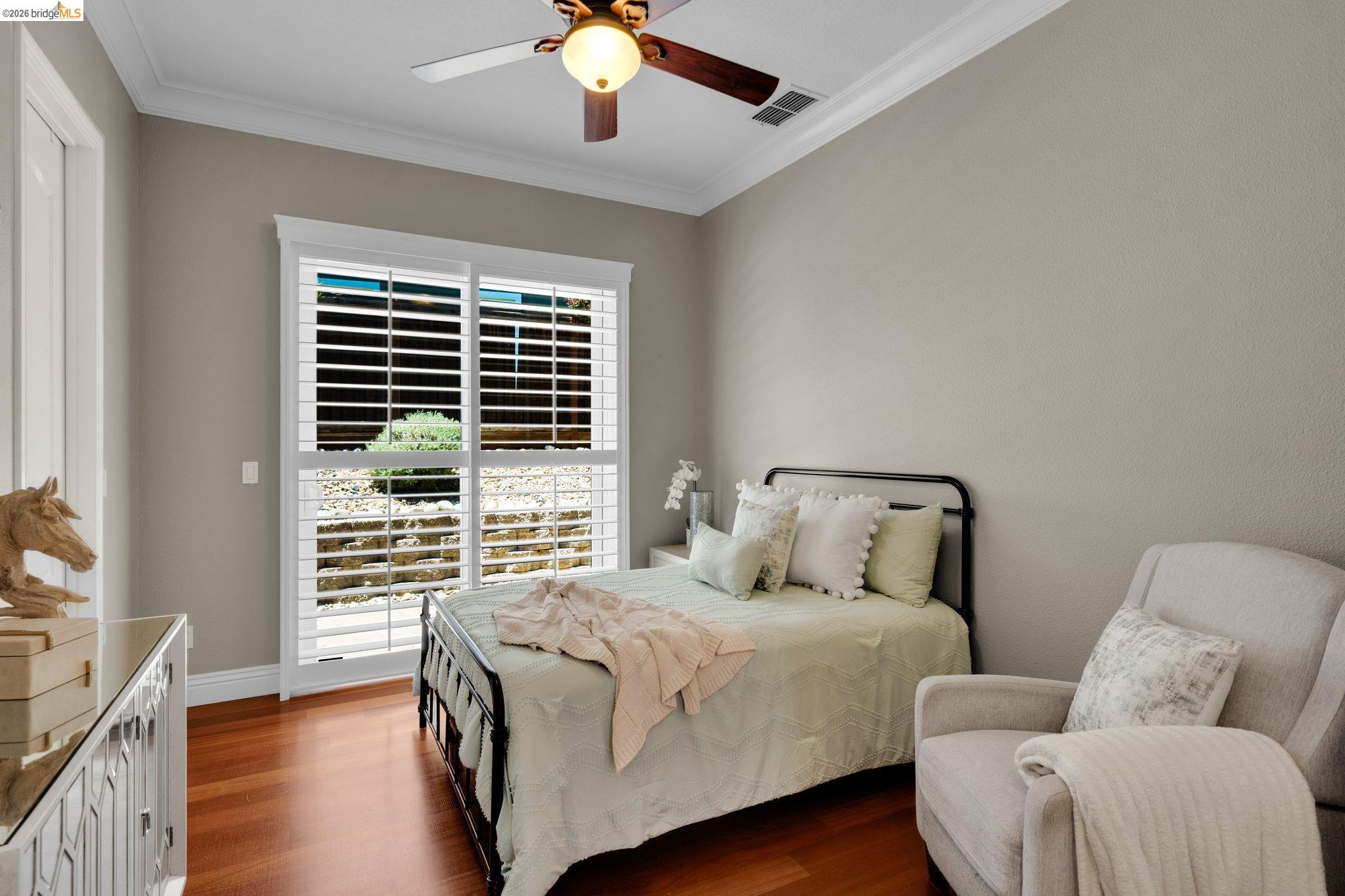 2513 Winged Foot Road Brentwood, CA 94513 - Photo 29 of 45 Room featuring warm wood-finish flooring, white plantation shutters, a ceiling fan with integrated lighting, crown molding, and neutral wall tones