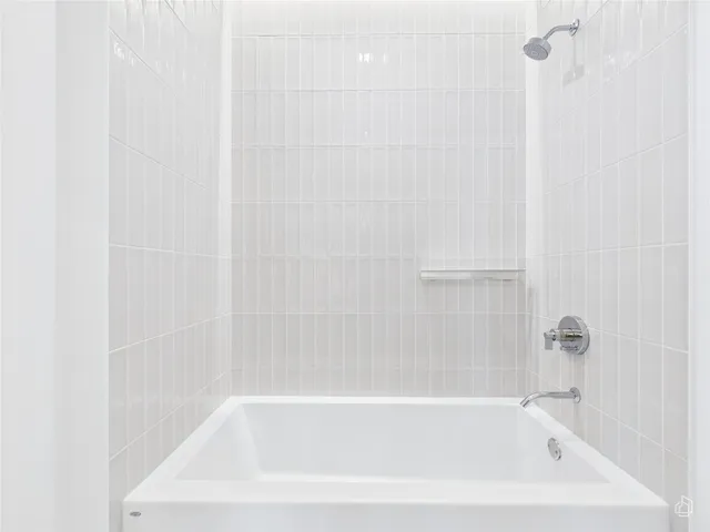 a white bath tub sitting next to a white sink and vanity