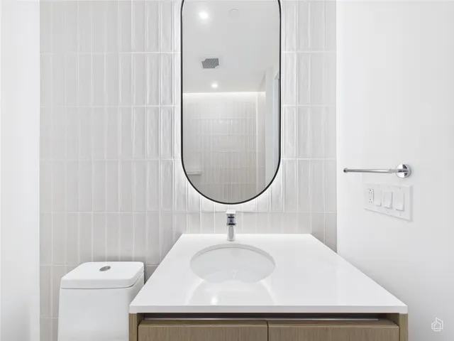 a bathroom with a sink a toilet and a mirror