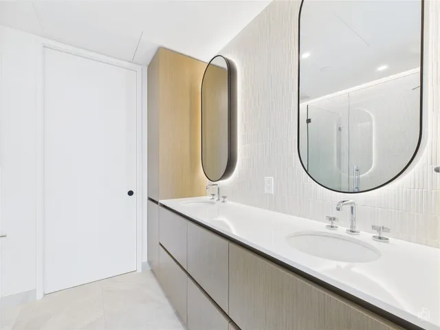 a bathroom with a double vanity sink and mirror
