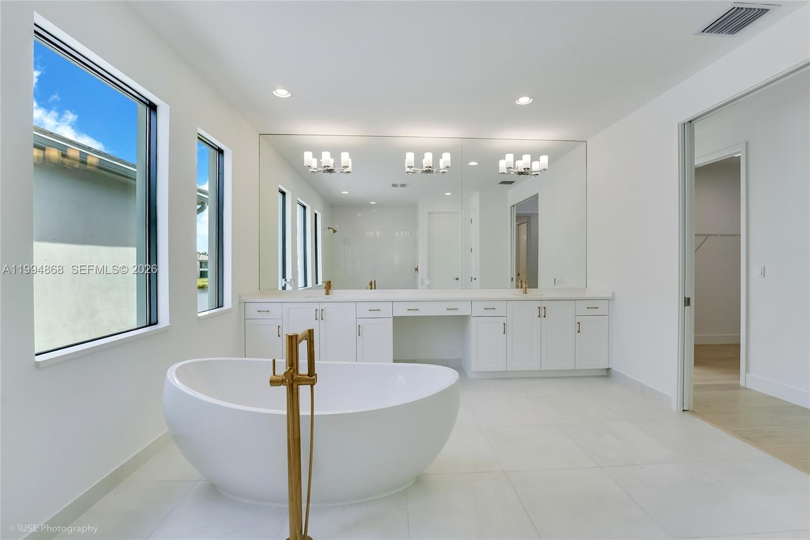 8095 Crystal Downs Avenue Boca Raton, FL 33434 - Photo 16 of 26 a bathroom with a tub a sink and a mirror