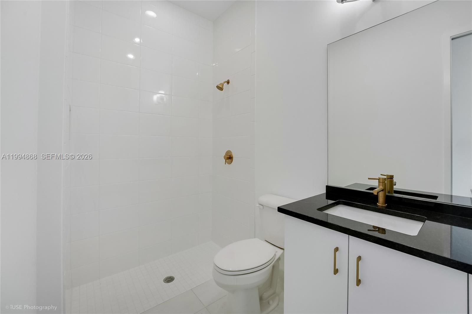 8095 Crystal Downs Avenue Boca Raton, FL 33434 - Photo 18 of 26 a bathroom with a granite countertop sink a toilet and a mirror
