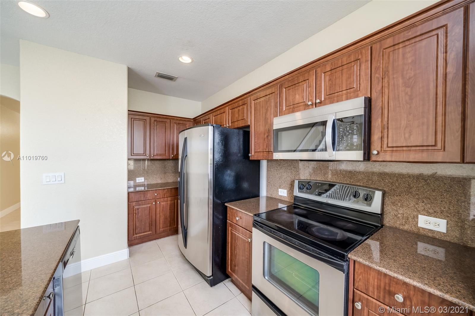 8437 Southwest 29th Street, Unit 102 Miramar, FL 33025 - Photo 15 of 29 a kitchen with stainless steel appliances granite countertop a refrigerator and a stove top oven