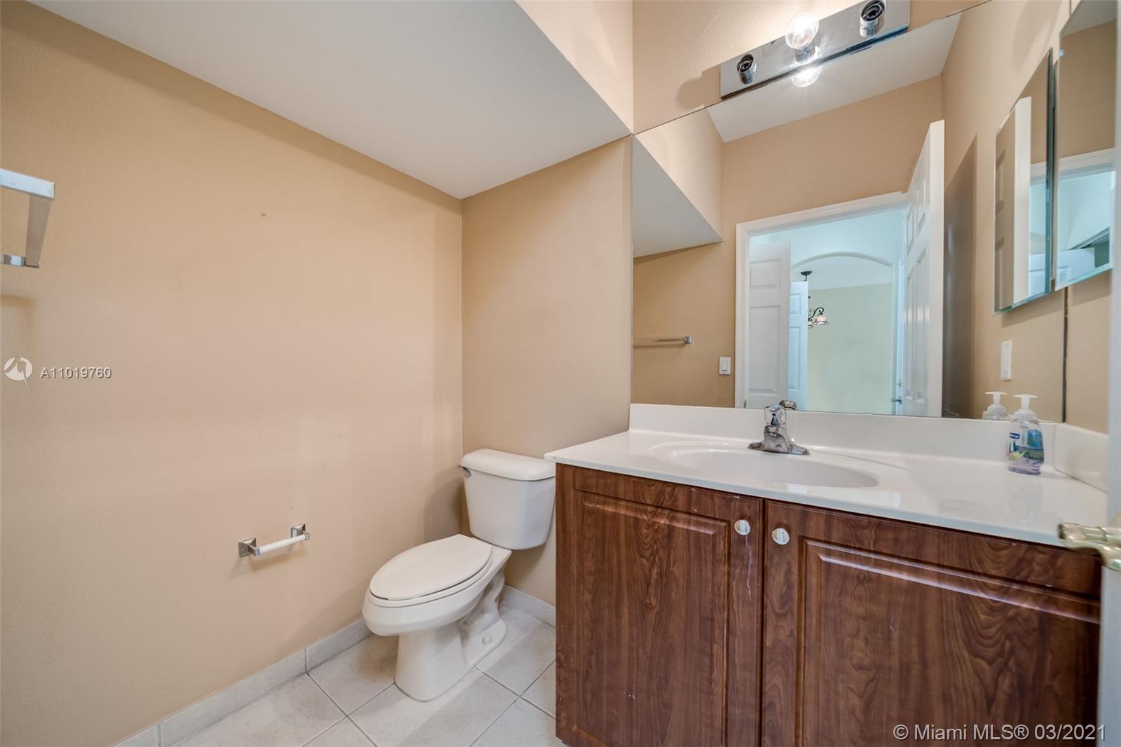 8437 Southwest 29th Street, Unit 102 Miramar, FL 33025 - Photo 9 of 29 a bathroom with a granite countertop sink a toilet and a mirror