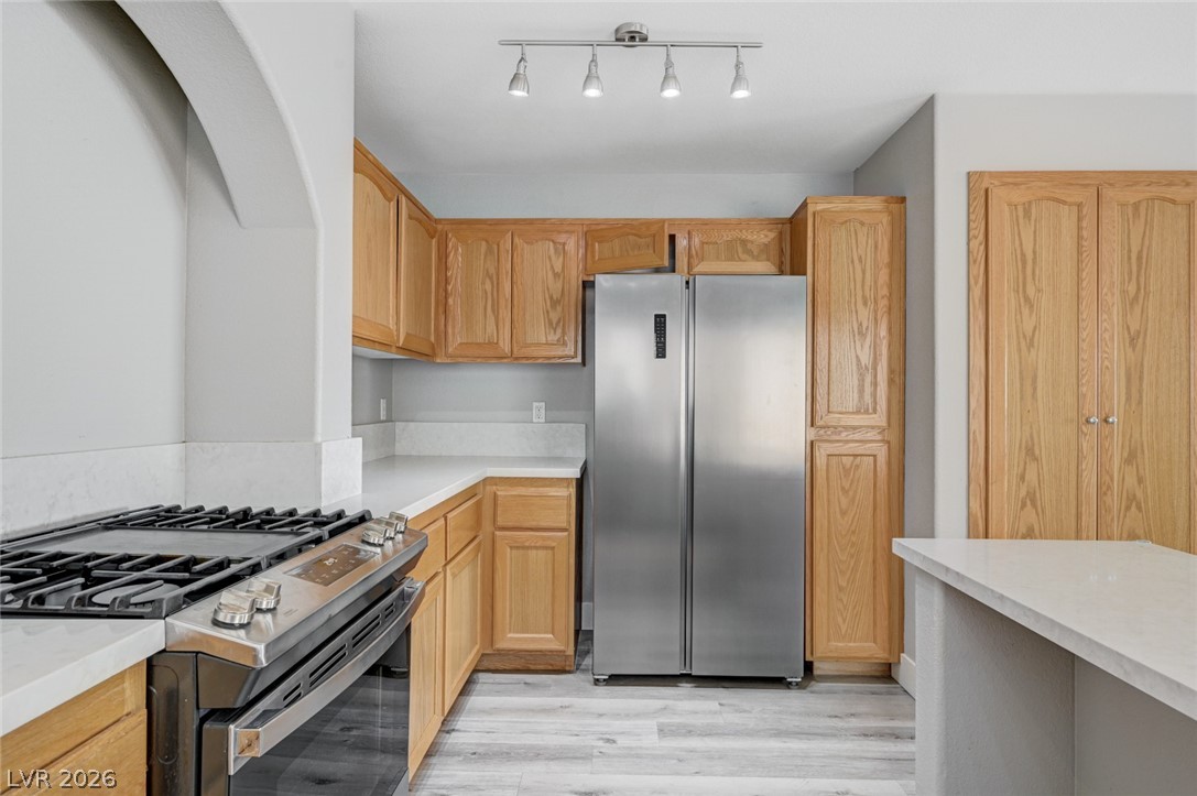 7259 Cestrum Road Las Vegas, NV 89113 - Photo 11 of 35 A well-appointed kitchen features a gas range, stainless steel appliances, and ample wooden cabinetry.