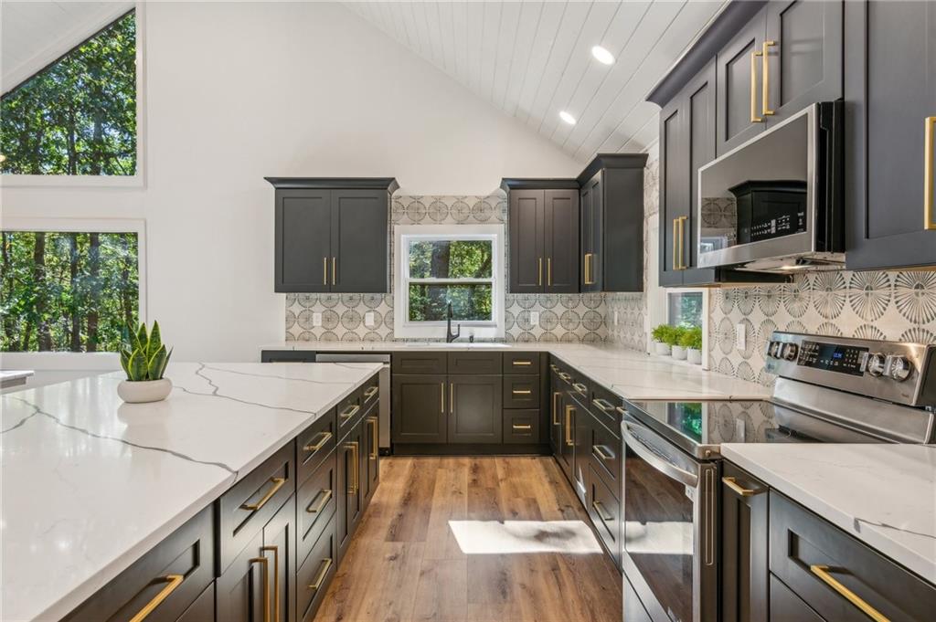 626 Petit Ridge Drive Big Canoe, GA 30143 - Photo 14 of 42 a kitchen with stainless steel appliances kitchen island granite countertop a sink stove and microwave