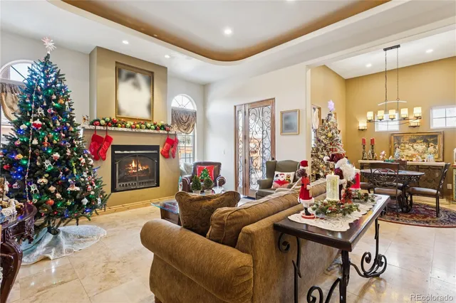 a living room with furniture a chandelier and a fireplace