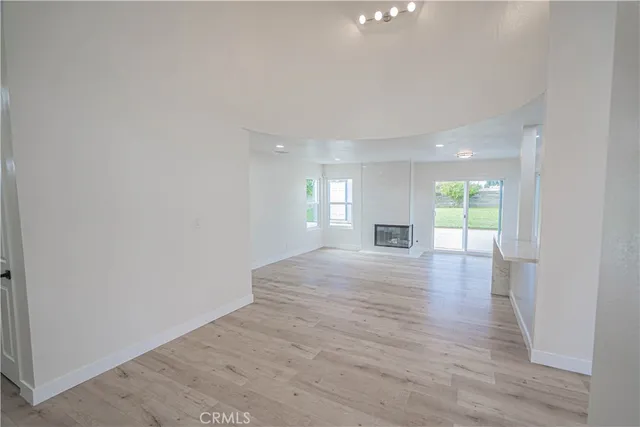 a view of empty room with wooden floor and windows