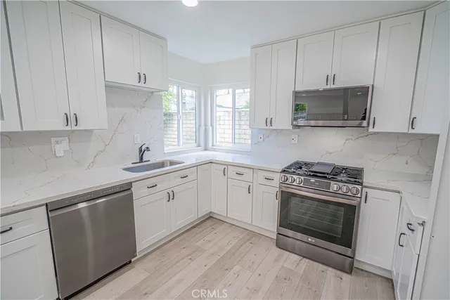 a kitchen with cabinets stainless steel appliances and a sink