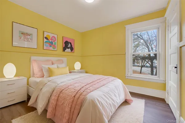 a bedroom with a bed and painting on the wall