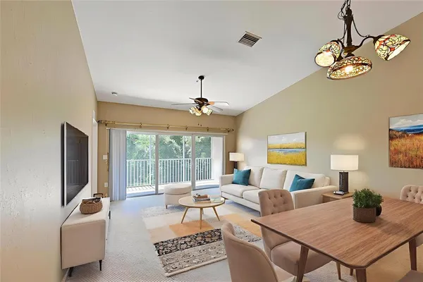 a living room with furniture a flat screen tv and a large window