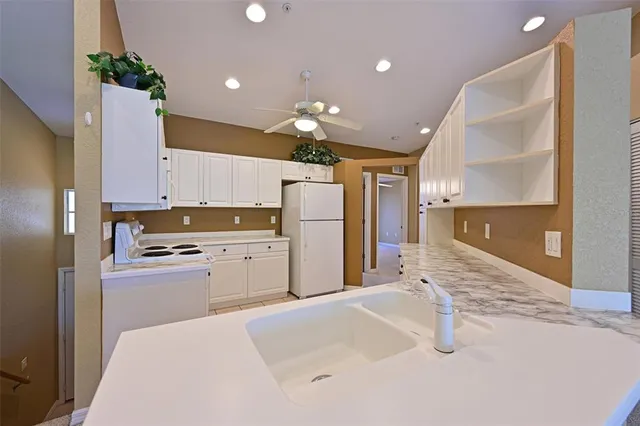 a kitchen with refrigerator and cabinets