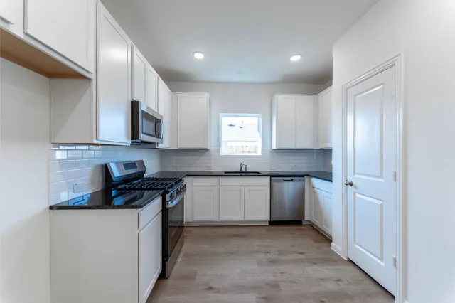 a kitchen with a sink stove and cabinets