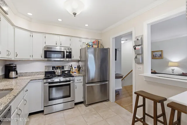 a kitchen with stainless steel appliances granite countertop a refrigerator stove microwave and sink