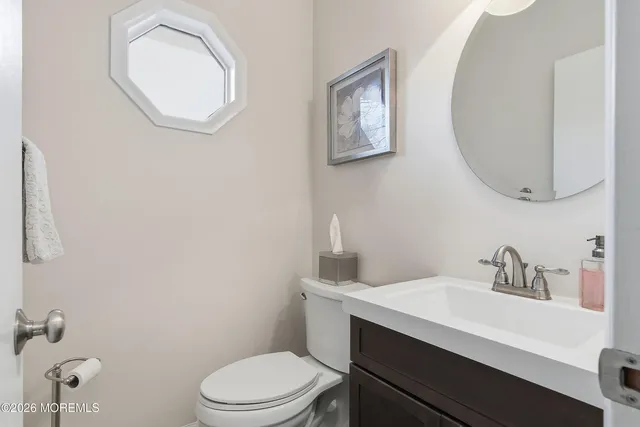 a bathroom with a sink mirror and toilet