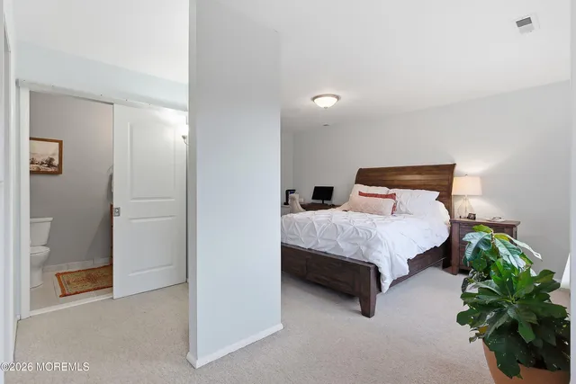 a bedroom with a bed and a potted plant