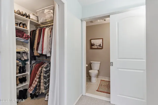 a view of walk in closet with clothes and shoes