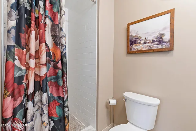 a bathroom with a toilet and a shower curtain