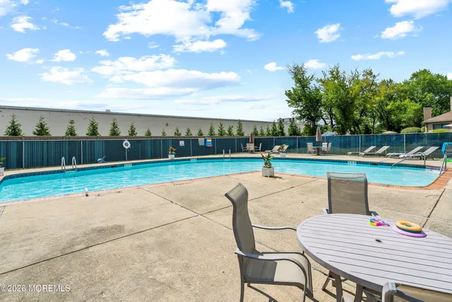 a view of a swimming pool with lawn chairs under an umbrella