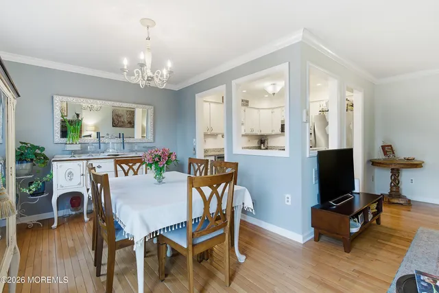 a dining room with furniture a chandelier and wooden floor