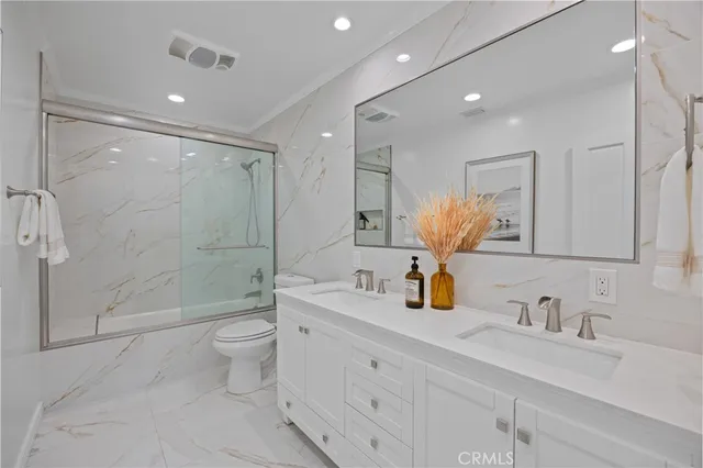 a bathroom with a double vanity sink toilet and shower