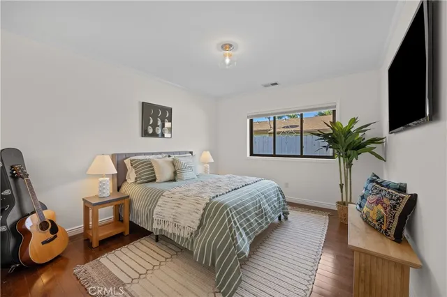 a bedroom with a bed a couch and potted plant