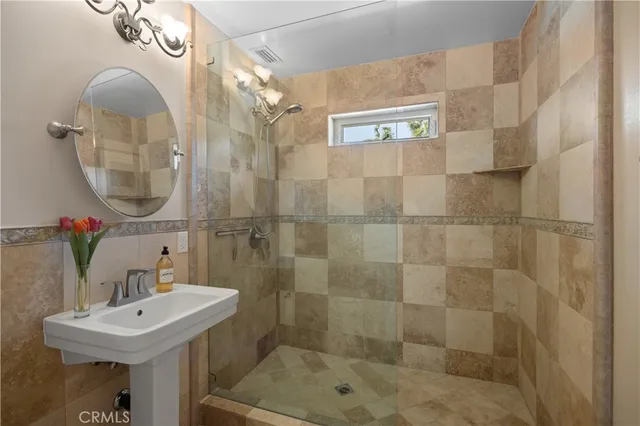 a bathroom with a sink a mirror and a shower